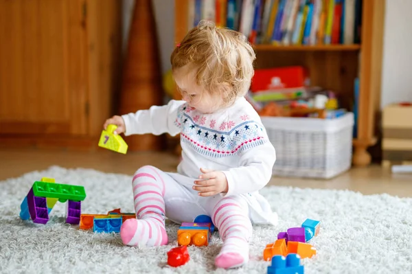 保育園で教育玩具で遊ぶ愛らしい幼児の女の子 家でカラフルな異なるプラスチックブロックで楽しんでいる幸せな健康的な子供 かわいい赤ちゃんの学習 および建物 — ストック写真