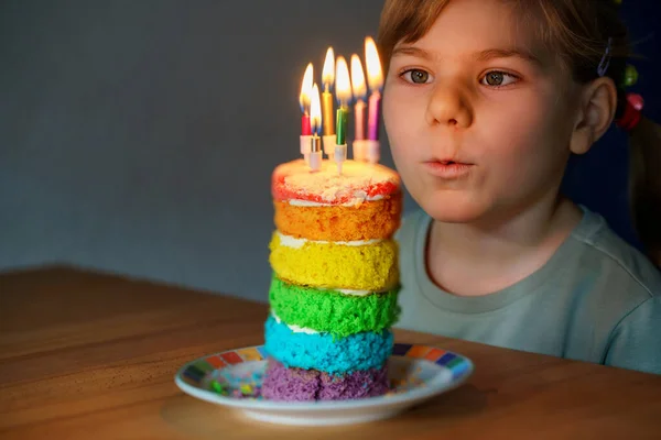 誕生日を祝う幸せな小さな就学前の女の子 手作りの虹のケーキ 屋内で子供の閉鎖 ケーキの上に6本のろうそくを吹く幸せな健康的な幼児 ケーキの選択的フォーカス — ストック写真
