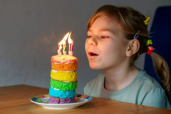 誕生日を祝う幸せな小さな就学前の女の子 手作りの虹のケーキ 屋内で子供の閉鎖 ケーキの上に6本のろうそくを吹く幸せな健康的な幼児 ケーキの選択的フォーカス — ストック写真