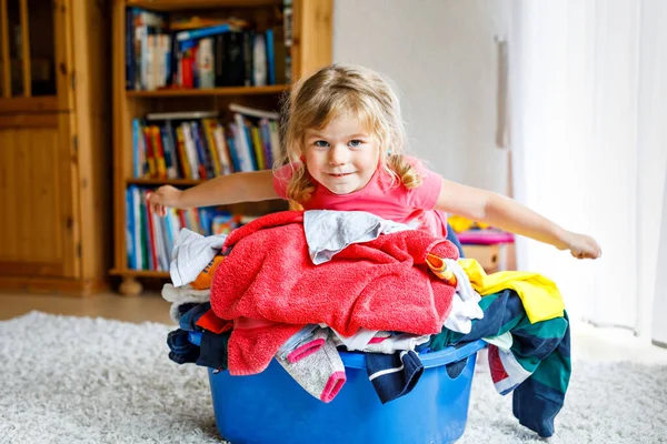 小女孩拿着一大篮新鲜干净的衣服准备熨烫 快乐漂亮的幼儿和小女儿帮妈妈做家务和穿衣 — 图库照片
