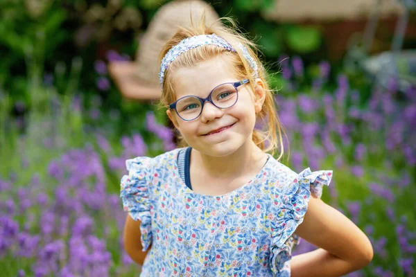 屋外に眼鏡をかけたかわいいプリスクールガールの肖像画 新しい青いメガネを着ているおかしな子供 庭の晴れた夏の日 — ストック写真