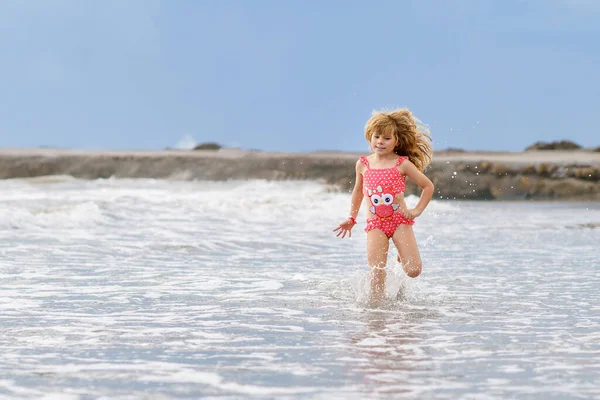 ハッピーチャイルド 水着の小さなプリスクールガール ランニングと夏の休暇中に波でジャンプ エキゾチックな熱帯ビーチで ファミリー ジャーニー オーシャン コースト — ストック写真