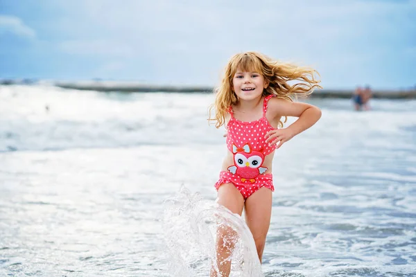 快乐的孩子 穿着泳衣的幼稚园女孩夏天在异国热带海滩度假时在波浪中奔跑和跳跃 海洋海岸的家庭旅程 — 图库照片