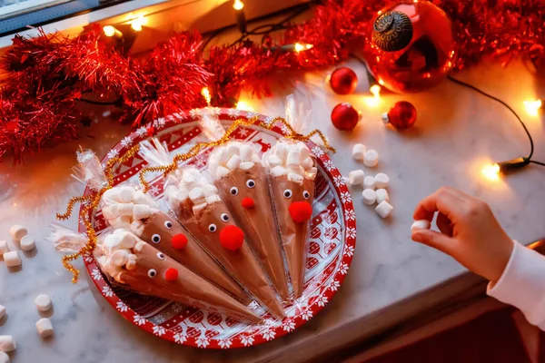 学龄前小女孩抱着用巧克力可可粉和棉花糖制成的驯鹿 圣诞期间儿童自制甜点饮料 — 图库照片