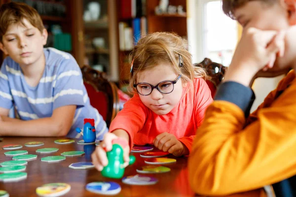 Family playing board game at home. Kids play strategic game. Little sister girl and two school brothers boys. Fun indoor activity. Siblings bond. Educational toys