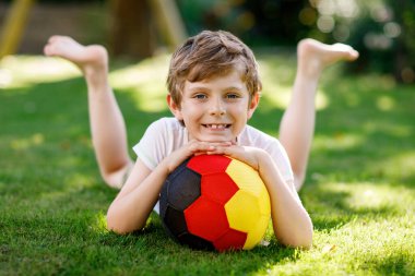 Aktif çocuk mutlu çocuk futbol topu Alman bayrağı renklerde oynamak. Sağlıklı çocuk futbol oyunu ve eylem açık havada ile eğleniyor.
