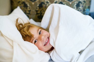 Yatakta uyuduktan sonra küçük şirin okul öncesi kız. Sevimli Anaokulu Çocuğu Gündüzleri Çocukların Sağlıklı Uykuları. Yeni yürümeye başlayan çocuğun derin uykusu. Çocuklar Dinleniyor