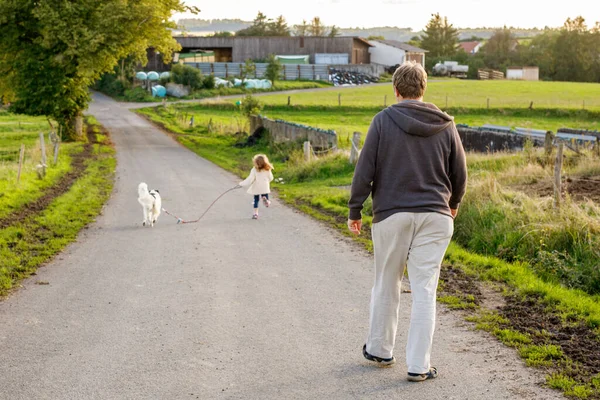 Baba, küçük anaokulu kızı ve aile köpeği dışarı çıkıyorlar. Orta yaşlı bir adam ve evcil hayvanı olan sevimli bir kız. Mutlu çocuk ve baba birlikte, eğleniyorlar.