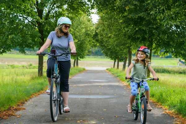 Ευτυχισμένη Οικογένεια Κάνει Ποδήλατο Έξω Και Χαμογελά Μητέρα Και Κόρη — Φωτογραφία Αρχείου