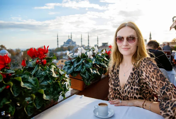 Woman travel in Istanbul and and drink turkey coffee in rooftop cafe near Hagia Sophia famous islamic Landmark mosque, Travel to Istanbul, Turkey background