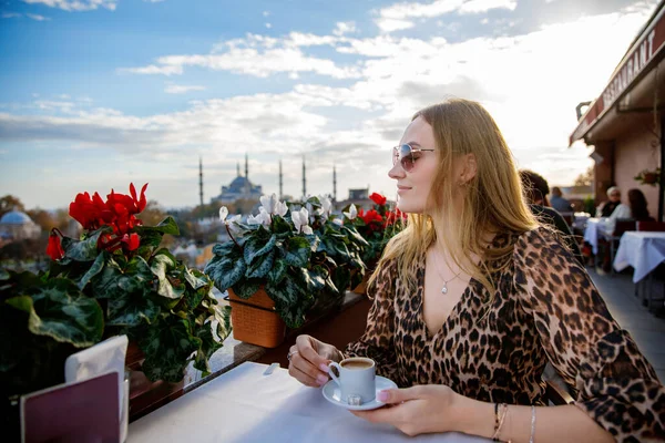 Woman travel in Istanbul and and drink turkey coffee in rooftop cafe near Hagia Sophia famous islamic Landmark mosque, Travel to Istanbul, Turkey background