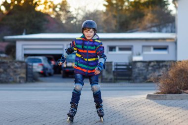 Sevimli okul çocuk çocuk şehrin silindirleriyle pateni. Mutlu sağlıklı çocuk koruma güvenlik elbiseleri Silindirler ile buz pateni. Spor yapma ve satır içi buz üzerinde paten öğrenme etkin öğrenci