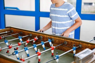 Masa futbolu oynayan çocuğun yakın çekimi. Mutlu heyecanlı çocuk aile oyunlarıyla eğleniyor kardeşleriyle ya da arkadaşlarıyla. Pozitif çocuk.