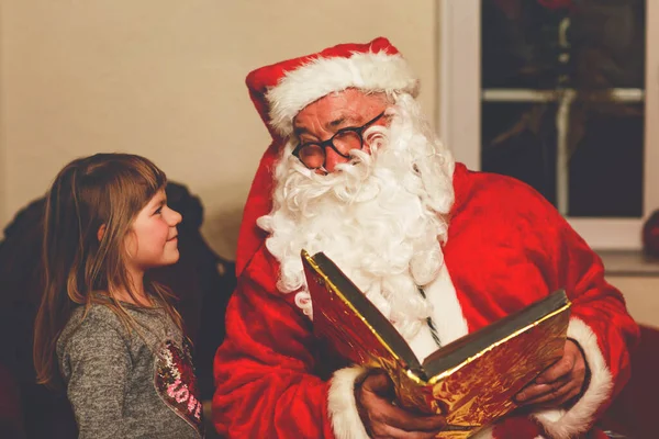 与圣诞老人交谈的小女孩用德语叫Nikolaus或Weihnachtsmann 快乐的微笑着等待礼物的孩子 圣诞老人与黄金书 圣诞节 — 图库照片