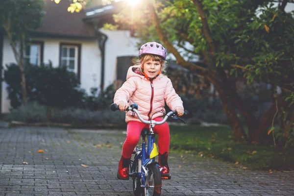 自転車に乗っている幼稚園児 屋外で自転車に乗った子供 暖かい夏の日に学校に行く途中で自転車に乗って楽しんでいる幸せな子供 安全なヘルメットで自転車のバランスをとることを学ぶプリスクーラー — ストック写真