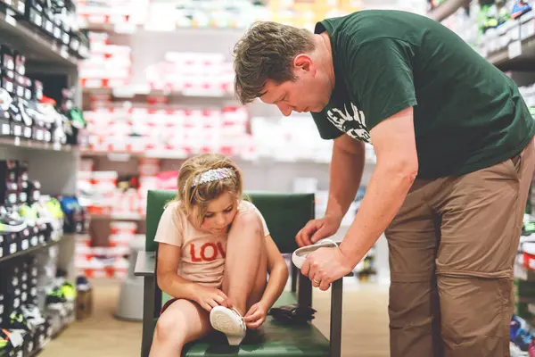 Little Girl and Father Shopping for Shoes in a Store. Child and Man Carefully Choose the Perfect Pair Together, Creating Cherished Memories and Strengthening Their Relationship as a Family.