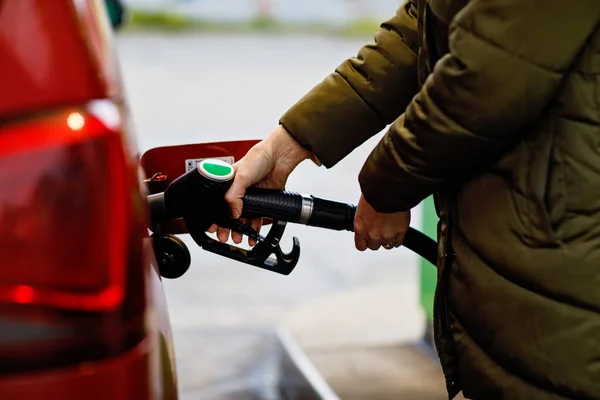 주유소에서 여성들의 노즐을 휘발유 가스로 연료를 자동차를 휘발유나 벤진으로 채우는 — 스톡 사진