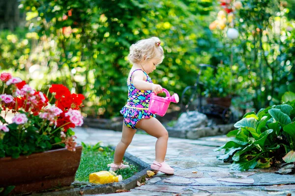 かわいい赤ちゃん女の子カラフルな水着水生植物で夏の暑い日の国内庭に花を咲かせて 愛らしい幼児子供用水とすることができますを再生すると楽しい時を過す — ストック写真