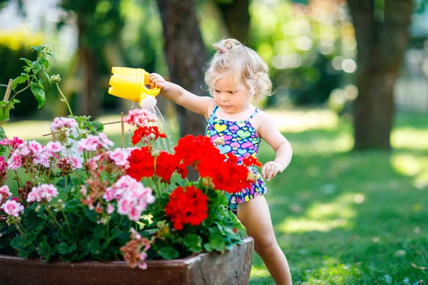 Schattig Klein Babymeisje Kleurrijke Badpak Drenken Planten Bloeiende Bloemen Binnenlandse — Stockfoto