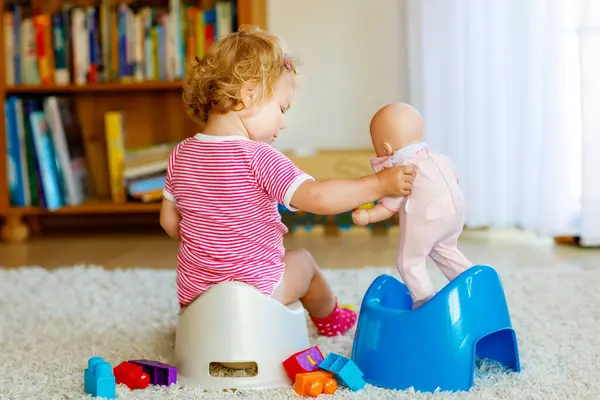 可愛い小さな12ヶ月の閉鎖幼児の女の子の子供はケチに座っています 人形のおもちゃで遊んでいる子供 トイレトレーニングのコンセプト 赤ちゃんの学習 発達のステップ — ストック写真