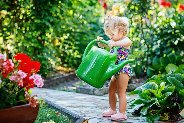 かわいい赤ちゃん女の子カラフルな水着水生植物で夏の暑い日の国内庭に花を咲かせて 愛らしい幼児子供用水とすることができますを再生すると楽しい時を過す — ストック写真