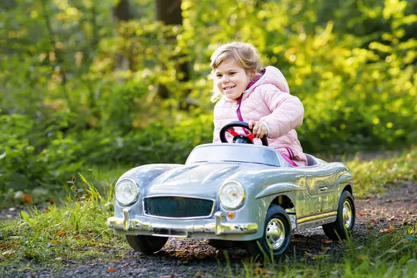 Ένα Κοριτσάκι Προσχολικής Ηλικίας Που Οδηγεί Ένα Μεγάλο Παλιό Αυτοκινητάκι — Φωτογραφία Αρχείου