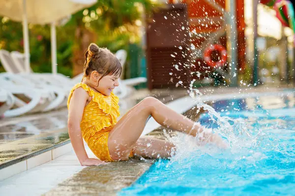 サンセットで屋外プールで遊ぶ幼稚園児 子供は屋外プールで泳ぐことを学び 水で飛び散り 楽しんで笑います 家族の休暇 健康な子供のスポーツ活動 ストック写真
