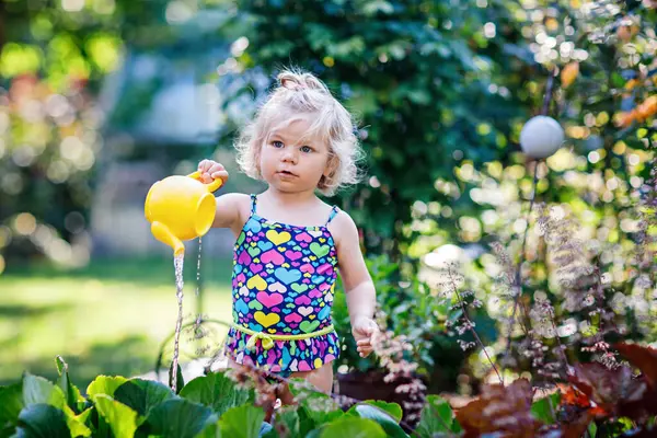 Schattig Klein Babymeisje Kleurrijke Badpak Drenken Planten Bloeiende Bloemen Binnenlandse — Stockfoto