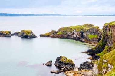 Carrick-a-Rede Köprüsü kıyısında, İrlanda kıyı şeridi üzerinde Kuzey İrlanda 'nın Antrim ilçesi Ballintoy yakınlarında meşhur ip köprüsü. Bulutlu bir günde Vahşi Atlantik Yolu