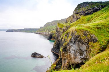 Carrick-a-Rede Köprüsü kıyısında, İrlanda kıyı şeridi üzerinde Kuzey İrlanda 'nın Antrim ilçesi Ballintoy yakınlarında meşhur ip köprüsü. Bulutlu bir günde Vahşi Atlantik Yolu