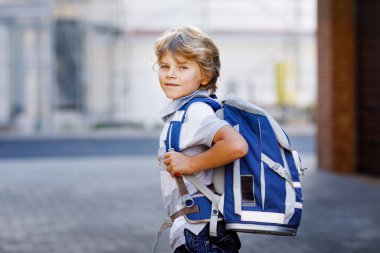 Sırt çantası ya da Almancası Ranzen olan küçük mutlu bir çocuk. Okul çocuğu okula gidiyormuş. Dışarıdaki sağlıklı sevimli çocuğun portresi. Öğrenci, öğrenci, okula dönün. İlkokul çağında..