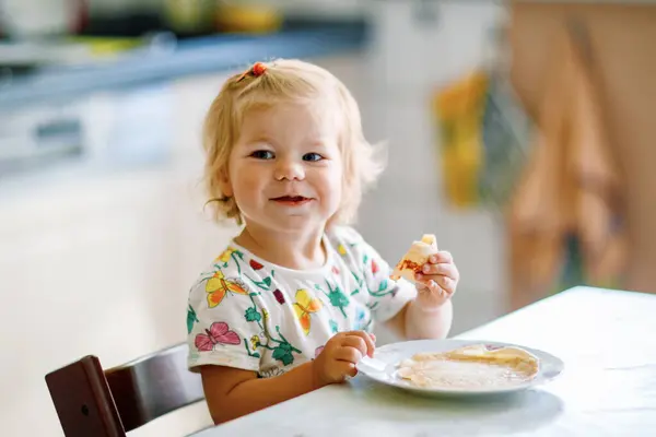 Szczęśliwa Dziewczynka Pyszne Naleśniki Siedząc Kuchni Cute Degustacja Dzieci Różnych Obrazy Stockowe bez tantiem