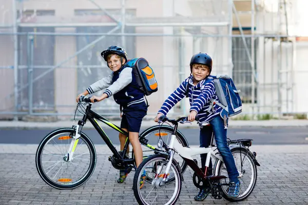 Dwóch Chłopców Kasku Jeździ Rowerze Mieście Plecakami Szczęśliwe Dzieci Kolorowych Zdjęcia Stockowe bez tantiem