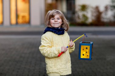 Anaokulundaki küçük kız, St. Martin töreni için mumlu geleneksel fenerler tutuyor. Çocuk, anaokulundaki çocuk ve aile geçidine bayılıyor. Alman geleneği Martinsumzug