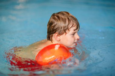 Etkin çok güzel okul öncesi çocuk olan küçük çocuk öğrenme bir kapalı havuzda yüzmek için swimmies. Aktif ve formda boş zaman çocuklar için. Spor yapma ve güvenli Yüzme öğrenme mutlu çocuk.