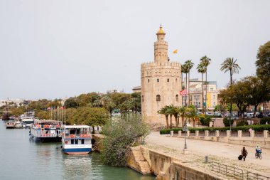 SEVILLE, SPAIN - 18 March, 2022: Historic Tower in Seville by the river, the Torre del Oro was built in the 13th century by the Almohades for defence.