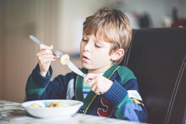 Sevimli küçük okullu çocuk makarna kapalı yemek. Sarışın çocuk iç mutfak veya okul kantin sevimli çocuk ve sağlıklı gıda, mantı ya da Rus mantı.