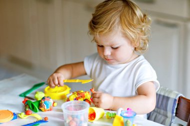 Evinde renkli kille sevimli, küçük bir kız. Sağlıklı bir bebek çocuk yuvasında ya da oyun okulunda hamur oynarken oyuncak yaratıyor. Kil kalıbı çıkaran küçük bir çocuk, yaratıcı aktivite.