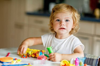 Evinde renkli kille sevimli, küçük bir kız. Sağlıklı bir bebek çocuk yuvasında ya da oyun okulunda hamur oynarken oyuncak yaratıyor. Kil kalıbı çıkaran küçük bir çocuk, yaratıcı aktivite.