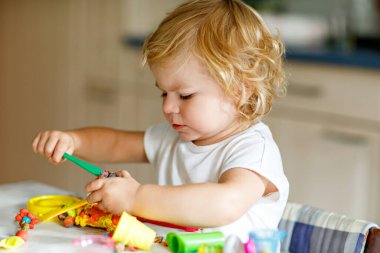 Evinde renkli kille sevimli, küçük bir kız. Sağlıklı bir bebek çocuk yuvasında ya da oyun okulunda hamur oynarken oyuncak yaratıyor. Kil kalıbı çıkaran küçük bir çocuk, yaratıcı aktivite.