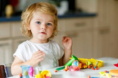 Evinde renkli kille sevimli, küçük bir kız. Sağlıklı bir bebek çocuk yuvasında ya da oyun okulunda hamur oynarken oyuncak yaratıyor. Kil kalıbı çıkaran küçük bir çocuk, yaratıcı aktivite.