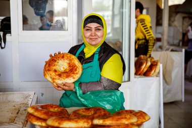 Taşkent, Özbekistan - 26 Mart 2024: Taşkent 'teki Chorsu pazarı, geleneksel ekmek satan kadın.