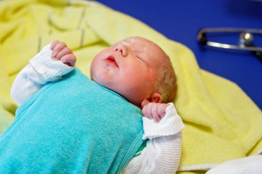 Yeni doğan çocuk doğumdan saniyeler ve dakikalar sonra ağlıyor. Havlu üzerinde küçük şirin bir kız bebek. Yeni hayat, başlangıç, sağlık hizmetleri