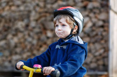 Köyde ya da şehirde bisiklet süren küçük bir çocuk. Dengeli bisikletteki mutlu anaokulu çocuğu, eğleniyor. Çocuklar için açık hava eğlencesi ve oyunlar