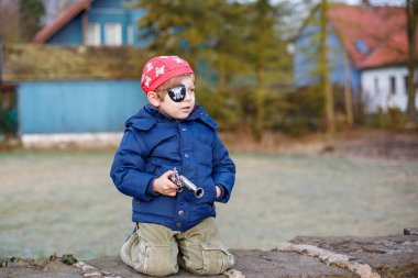 Korsan kostümlü, dışarıda 4 yıllık anaokulu çocuğu. Mutlu çocuk Almancada Büyüleyici denilen karnavalı kutluyor.