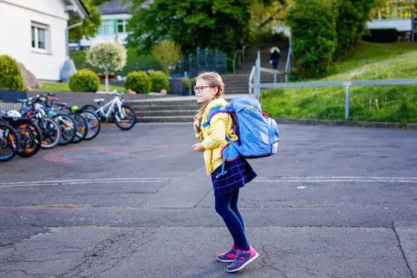 Küçük kız okula yürüyor. Okul bahçesinde çantalı ve gözlüklü şirin bir çocuk. Okula dönelim. Mutlu okul zamanları.