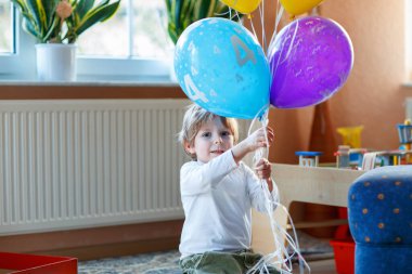 4. yaş gününü renkli balonlarla kutlayan küçük mutlu anaokulu çocuğu, çocuk odasında. Sevimli heyecanlı çocuk eğleniyor.