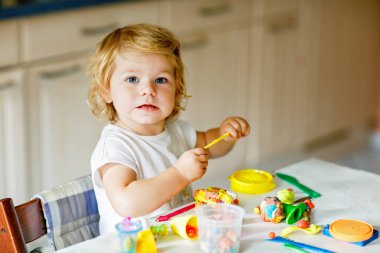 Evinde renkli kille sevimli, küçük bir kız. Sağlıklı bir bebek çocuk yuvasında ya da oyun okulunda hamur oynarken oyuncak yaratıyor. Kil kalıbı çıkaran küçük bir çocuk, yaratıcı aktivite.