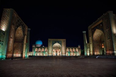 Semerkant, Özbekistan 'daki renkli Registan Meydanı. Gece Samarqand. Eski Arapça 'da Tanrı duvarlarda büyüktür..