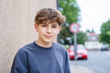 Kameraya bakan gülümseyen okul çocuğunun portresi. Kameraya güvenle gülümseyen mutlu ergen çocuk. Öğrenci hayatından zevk alan bir okul çocuğunun portresi. Eğitim ve gençlik yaşam tarzı kavramı